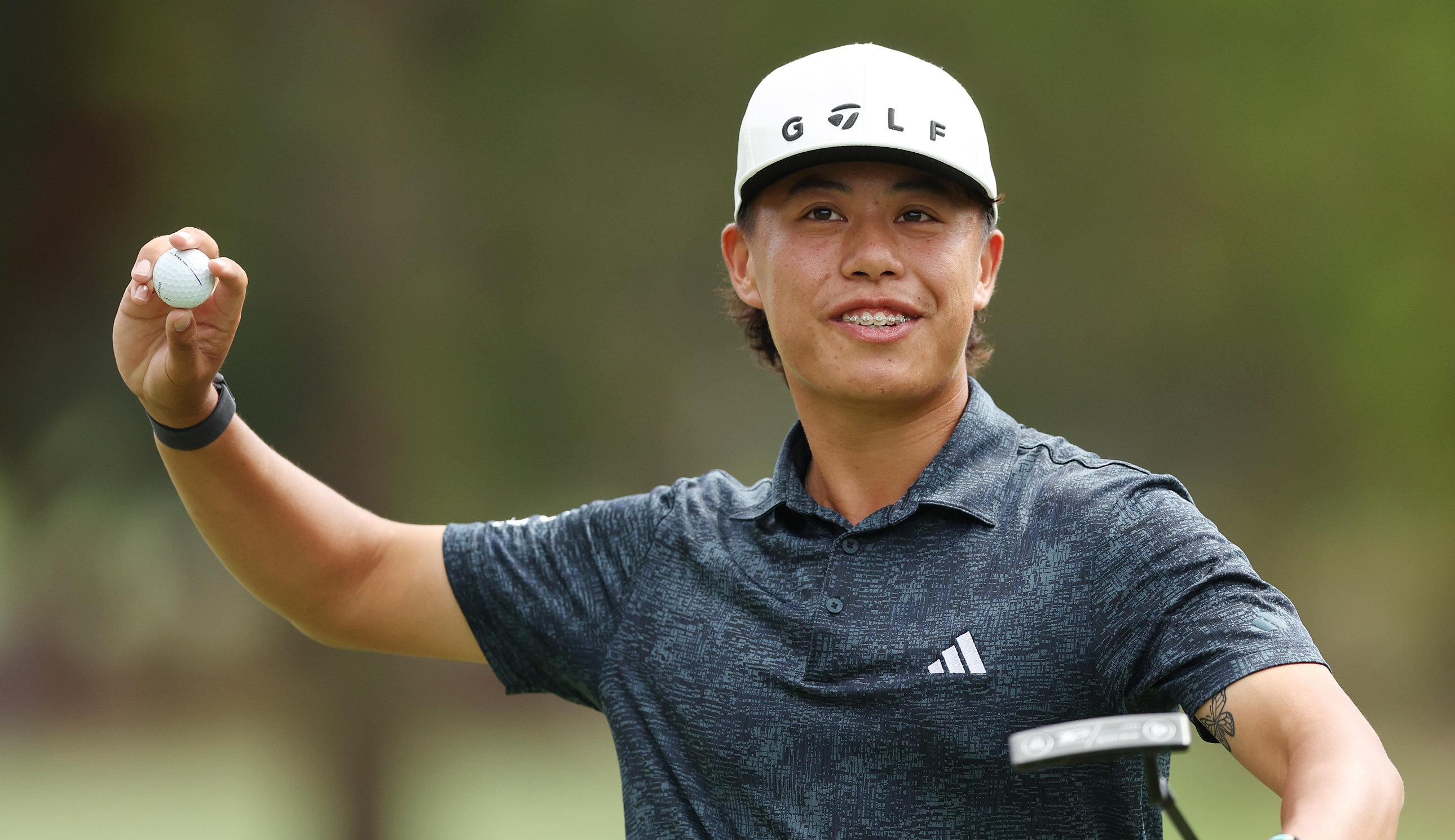 Jeffrey Guan throws a golf ball 
