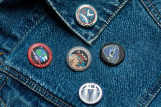 closeup of a denim jacket adorned with five small, circular buttons.