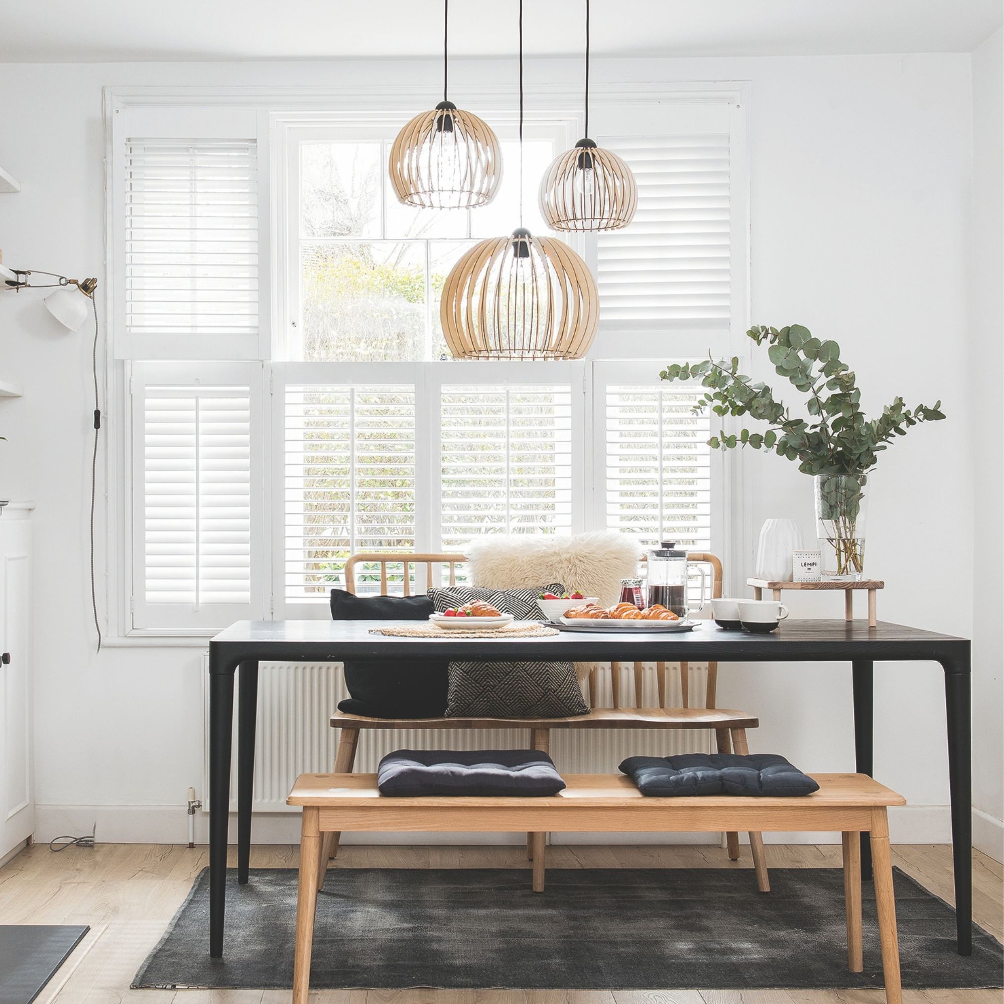 A bright dining space with three pendants and wooden accents