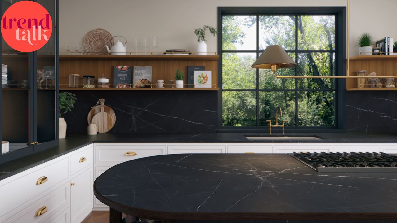 Black kitchen units, countertop, and island next to large window