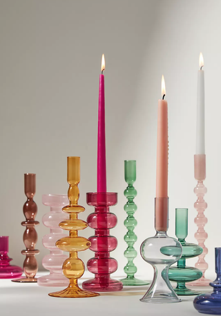 colorful candlesticks with a wavy design, some with tapered candles sitting inside