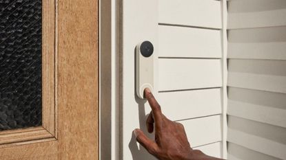 best wireless doorbell: Google Nest Doorbell Battery mounted to outside door frame, being pressed