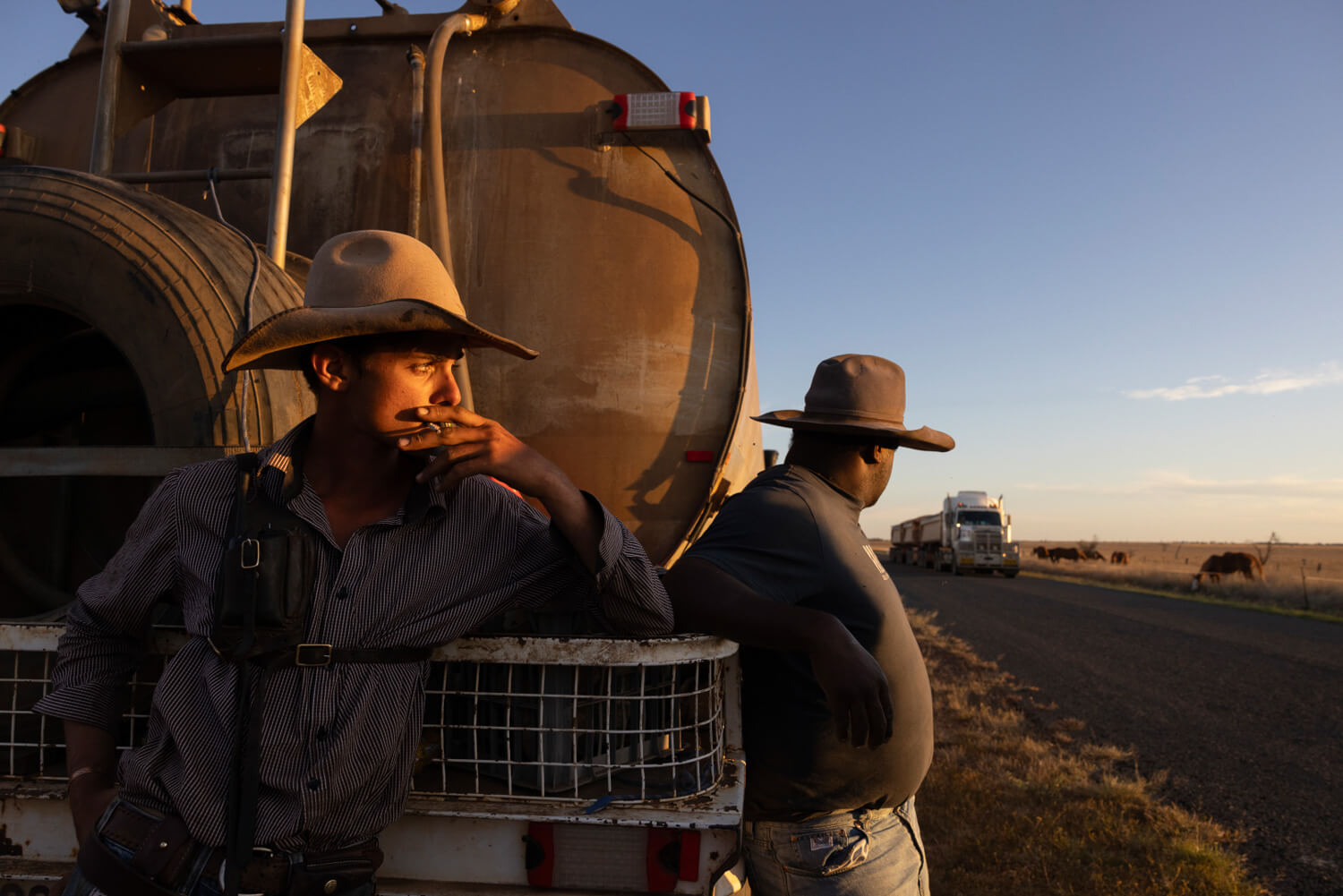 Drover smoking cigarette looking towards sunset.