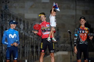 Team Jumbos Slovenian rider Primoz Roglic C holds his son Lev as celebrates winning the 2021 La Vuelta cycling tour of Spain flanked by Team Movistars Spanish rider Enric Mas L and Team Bahrains Australian rider Jack Haig after the 21st and final stage a 338 km timetrial from Padron to Santiago de Compostela on September 5 2021 Photo by MIGUEL RIOPA AFP Photo by MIGUEL RIOPAAFP via Getty Images
