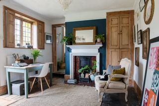 study with statement navy blue fireplace set against white walls