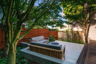 a small patio in a garden with a firepit