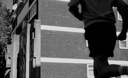 man running near London brutalist building 