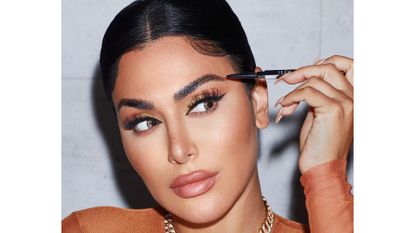 Huda Kattan with brow pencil