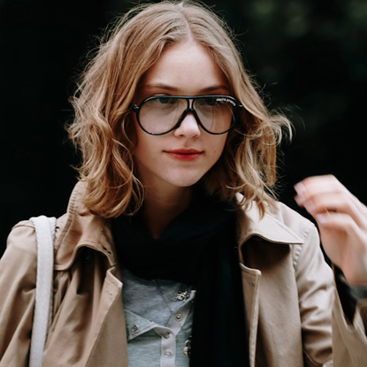 woman wearing a trench and a scarf and glasses 