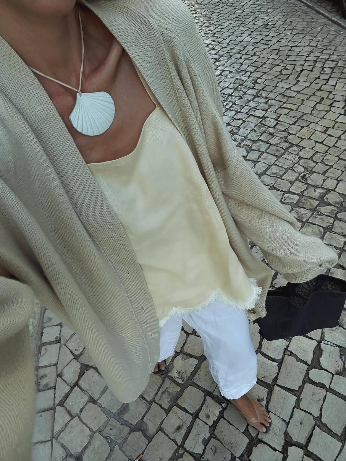 @anoukyve wears white trousers cream top and cardigan