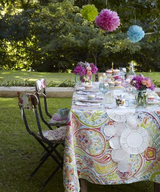 An outdoor table decorated with bright prints for a tea party