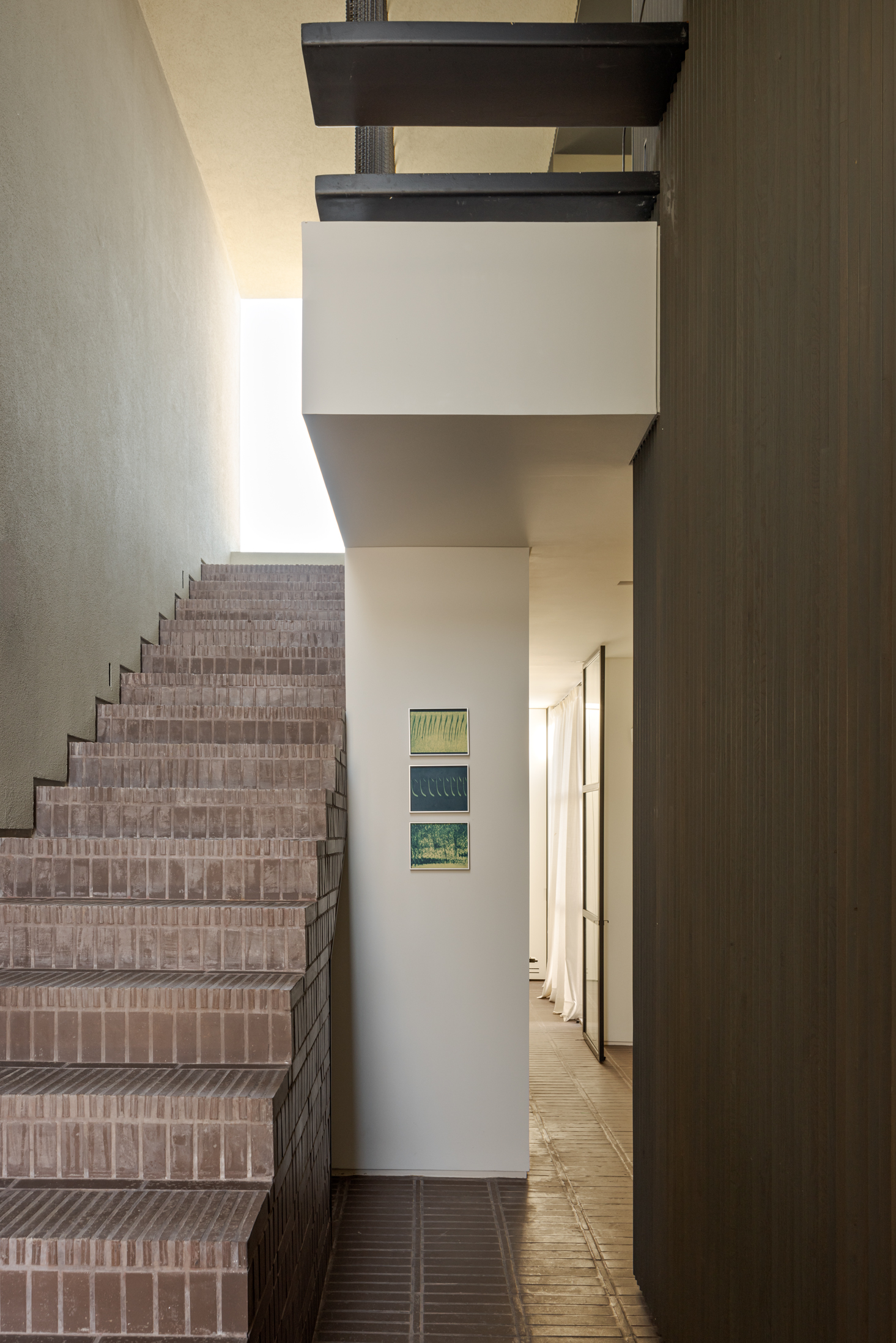 The terracotta clad staircase leads up to the living spaces from the ground floor