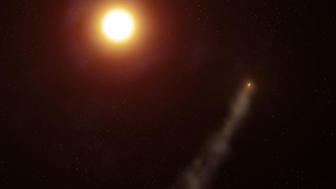 An alien planet trailing a long comet-like tail around red-orange star