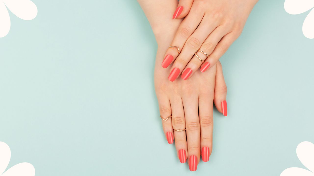 Bird&#039;s-eye view of woman&#039;s hands with long manicured nails painted coral to illustrate acrylic nails