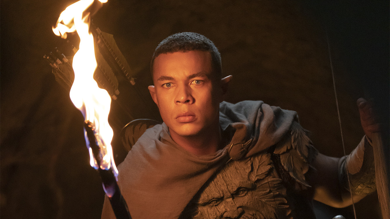 Ishmael Cruz Cordova (Arundir) with a torch in a dark area in Lord of the Rings: The Rings of Power
