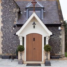 exterior of church with potted plant and wooden door