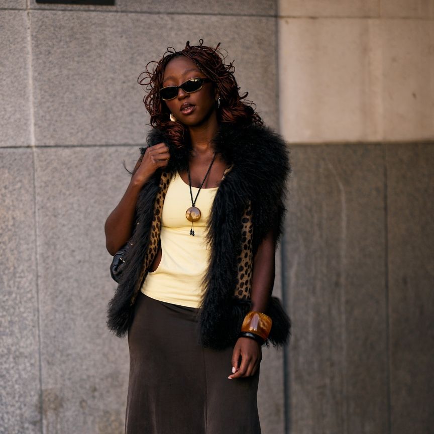a black woman in a leopard jacket with long hair and sunglasses