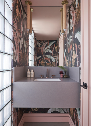 Tropical-inspired pink powder room using wallpaper