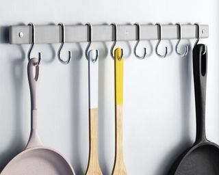 wall hooks with pans hanging off them, to show one of w&h's pan storage ideas