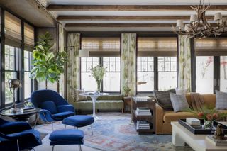 A large open plan living room featuring a bold accent of blue and yellow sofas and chairs