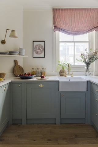 Small blue kitchen with striped blind