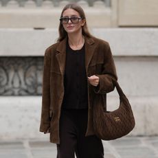 PARIS, FRANCE - OCTOBER 28: Diane Batoukina wears long straight light brown hair, oversized rectangular sunglasses by Kaleos, a brown suede oversized blazer jacket by Source Unknown, a dark brown knit sweater and matching pants by Dissh, brown suede sneakers by Alohas, and a quilted brown suede Miu Miu bag, during a street style fashion photo session, on October 28, 2025 in Paris, France. (Photo by Edward Berthelot/Getty Images)