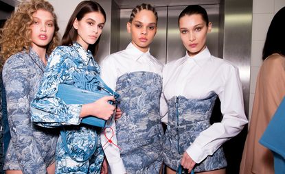 Backstage at Off-White A/W 2018 Paris show with models in tailored suits in a blue sporting tapestry
