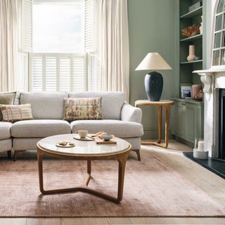 living room with large rug, coffee table, sofa and side table