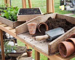 potting table with soil, pots and trowel