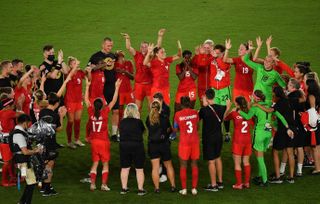 Canada players and staff celebrate after winning the gold medal match in the women's football at the Tokyo 2020 Olympics.