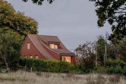 image of Clay Rise by Templeton Ford, a brick house with a curved roof in west sussex countryside