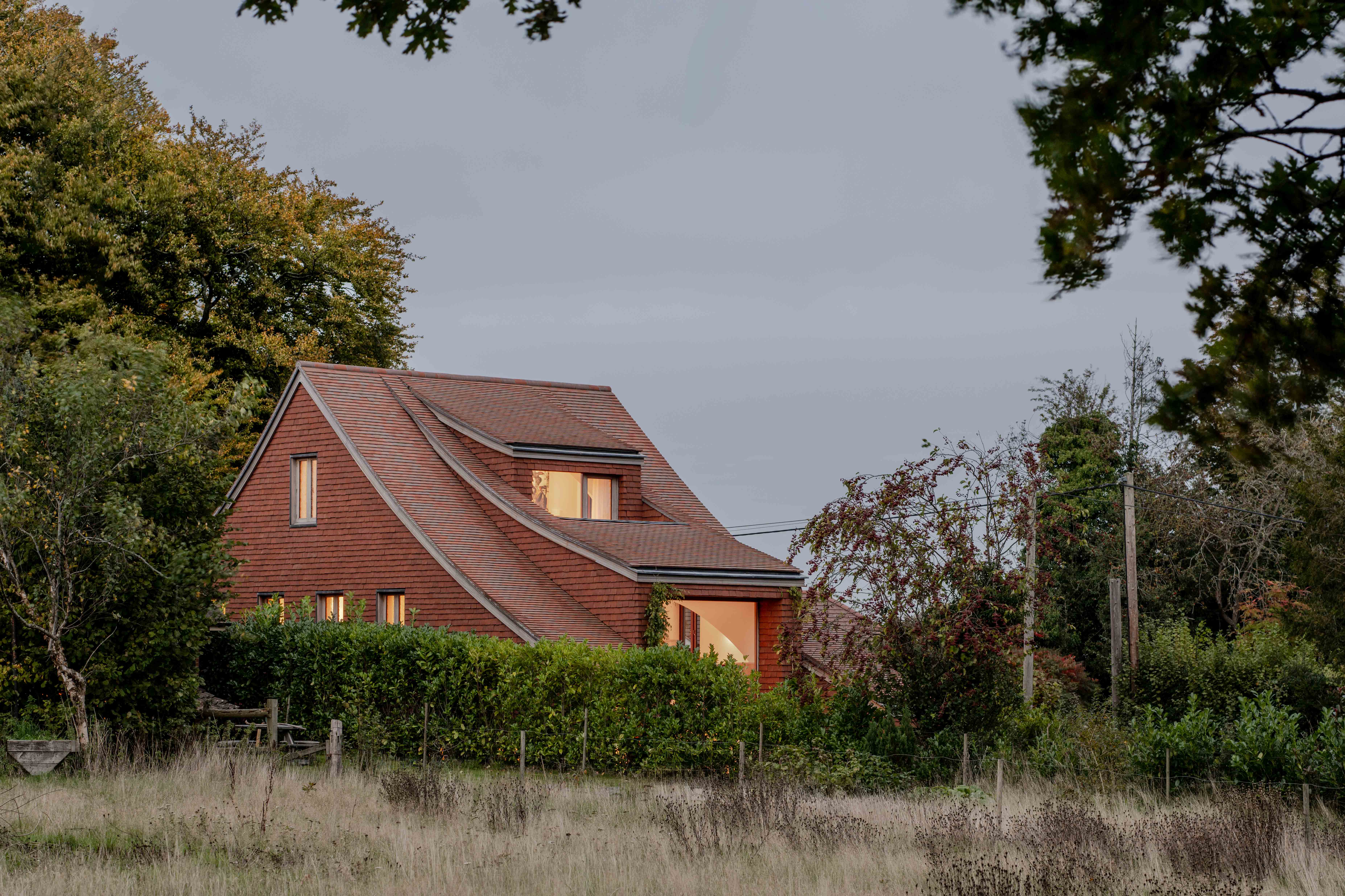 image of Clay Rise by Templeton Ford, a brick house with a curved roof in west sussex countryside