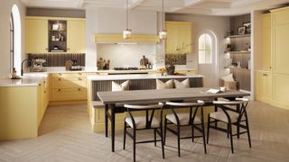 large kitchen diner with yellow cabinets and kitchen island with integrated banquette seating and dining table