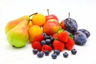 Several types of fuit, including blueberries, strawberries, pears and apples, sit against a white background. 