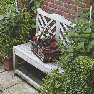 wicker baskets with white bench and plants and pots