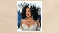 Image of Diana Ross smiling with long curly hair and sporting a mauve pink eyeshadow and lipstick combination, wearing a silver jewel-embellished V-neck gown and a fluffy white hat, on a neutral background