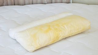 Yellow stains on a white bed pillow