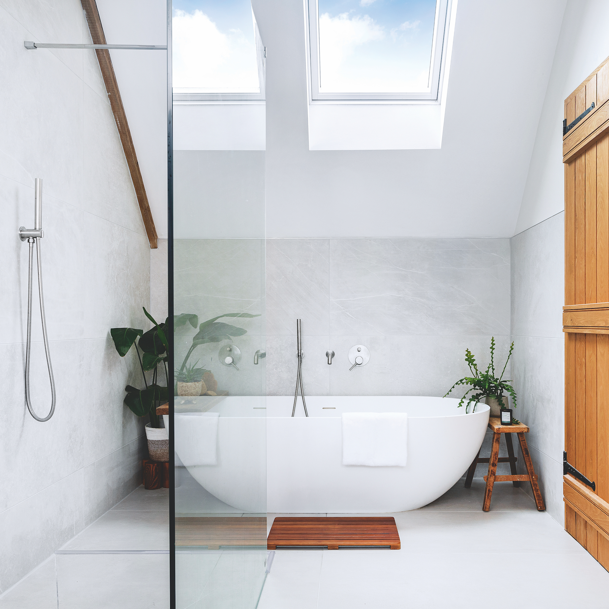 bathroom with contemporary white freestanding bath and a shower screen