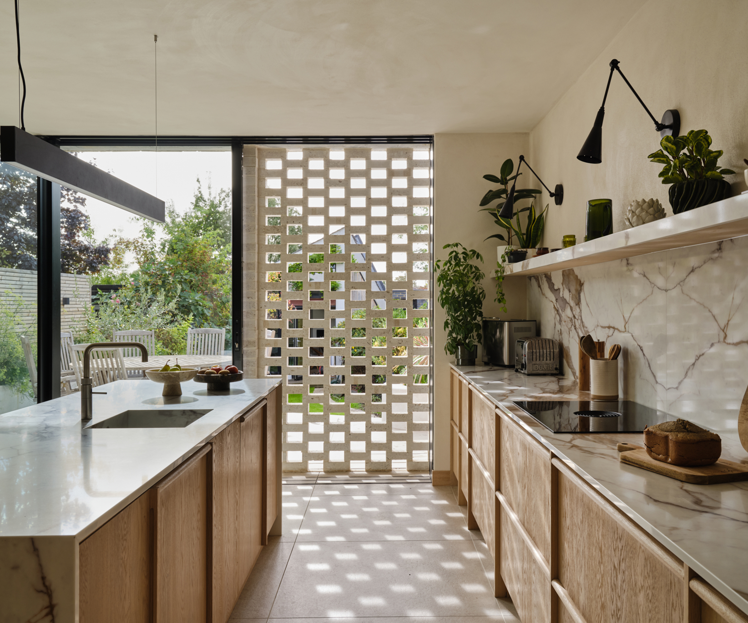modern wooden kitchen with glazed patio doors and brick latticework opening