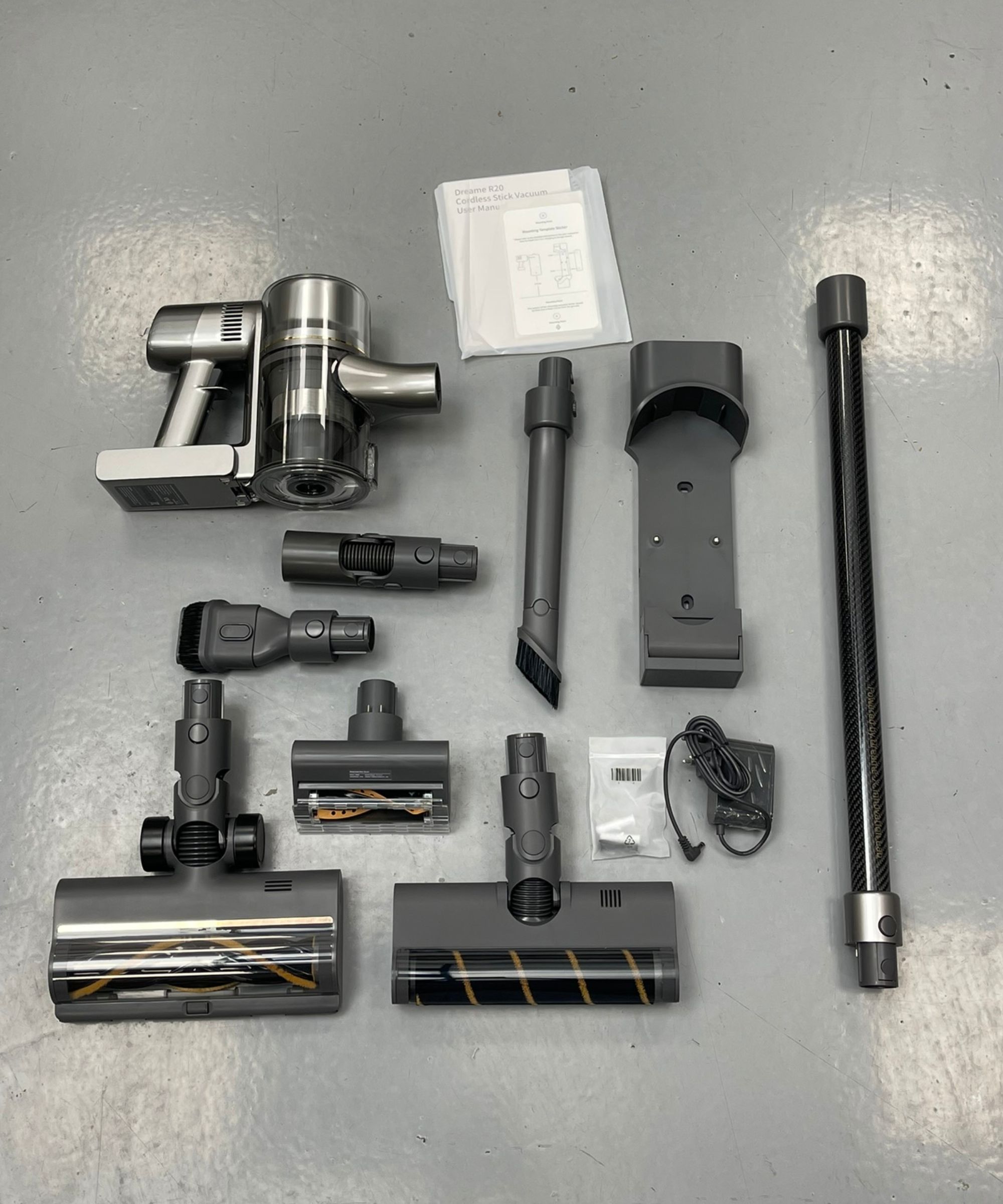 All parts and attachments of the Dreame R20 on gray linoleum floor in Future test center