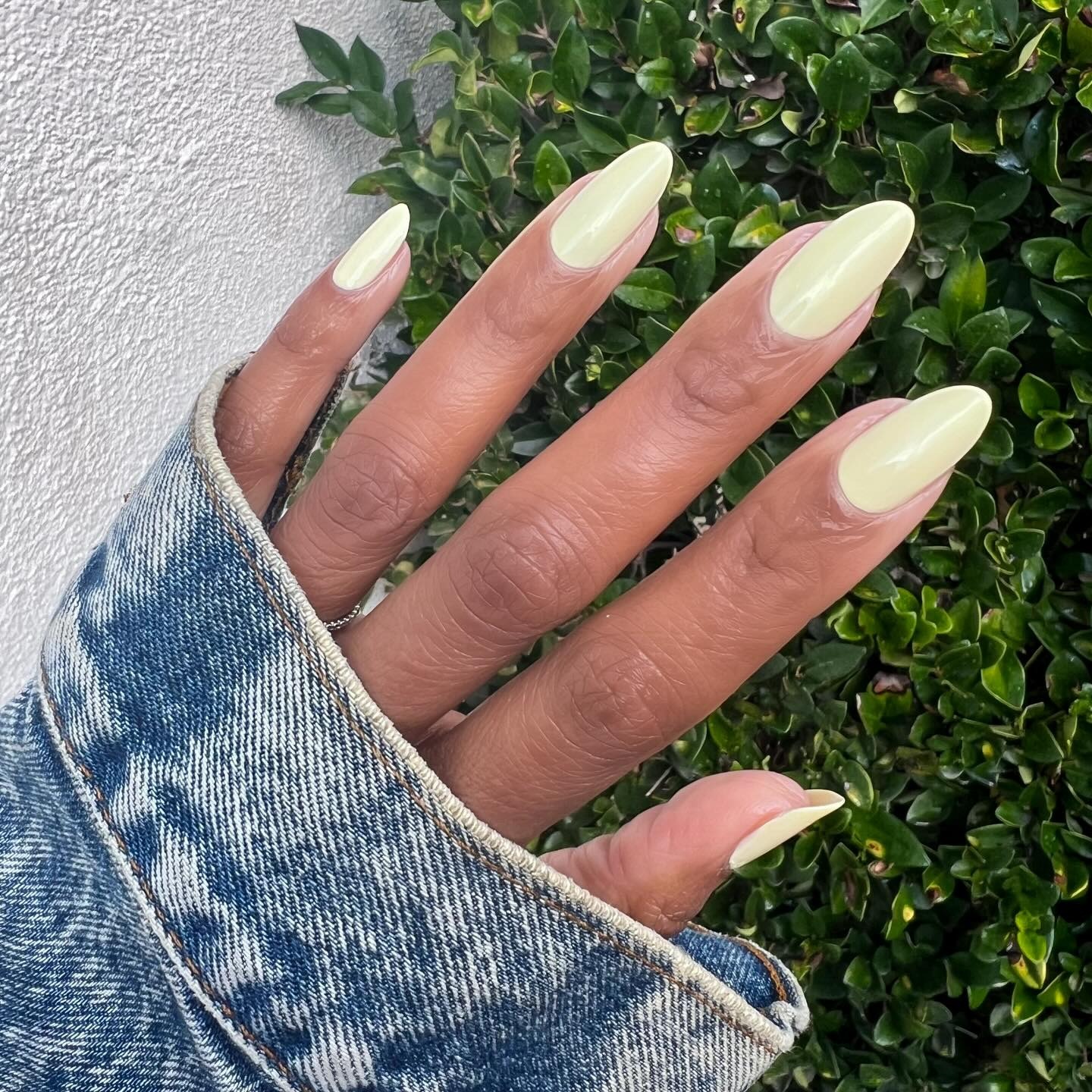 An almond-shaped, pale yellow manicure