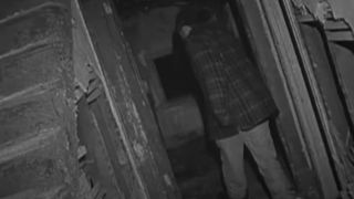 A brave soul walking through an abandoned house in The Blair Witch Project.