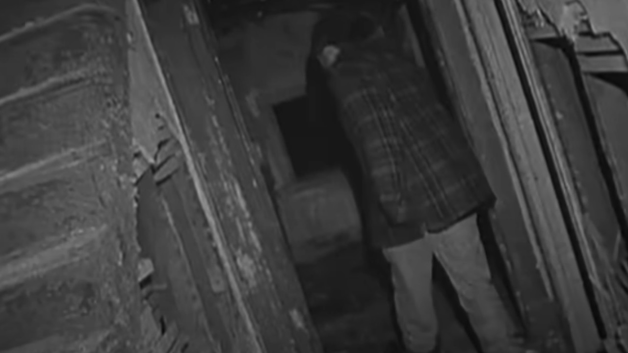 A brave soul walks through an abandoned house in The Blair Witch Project.