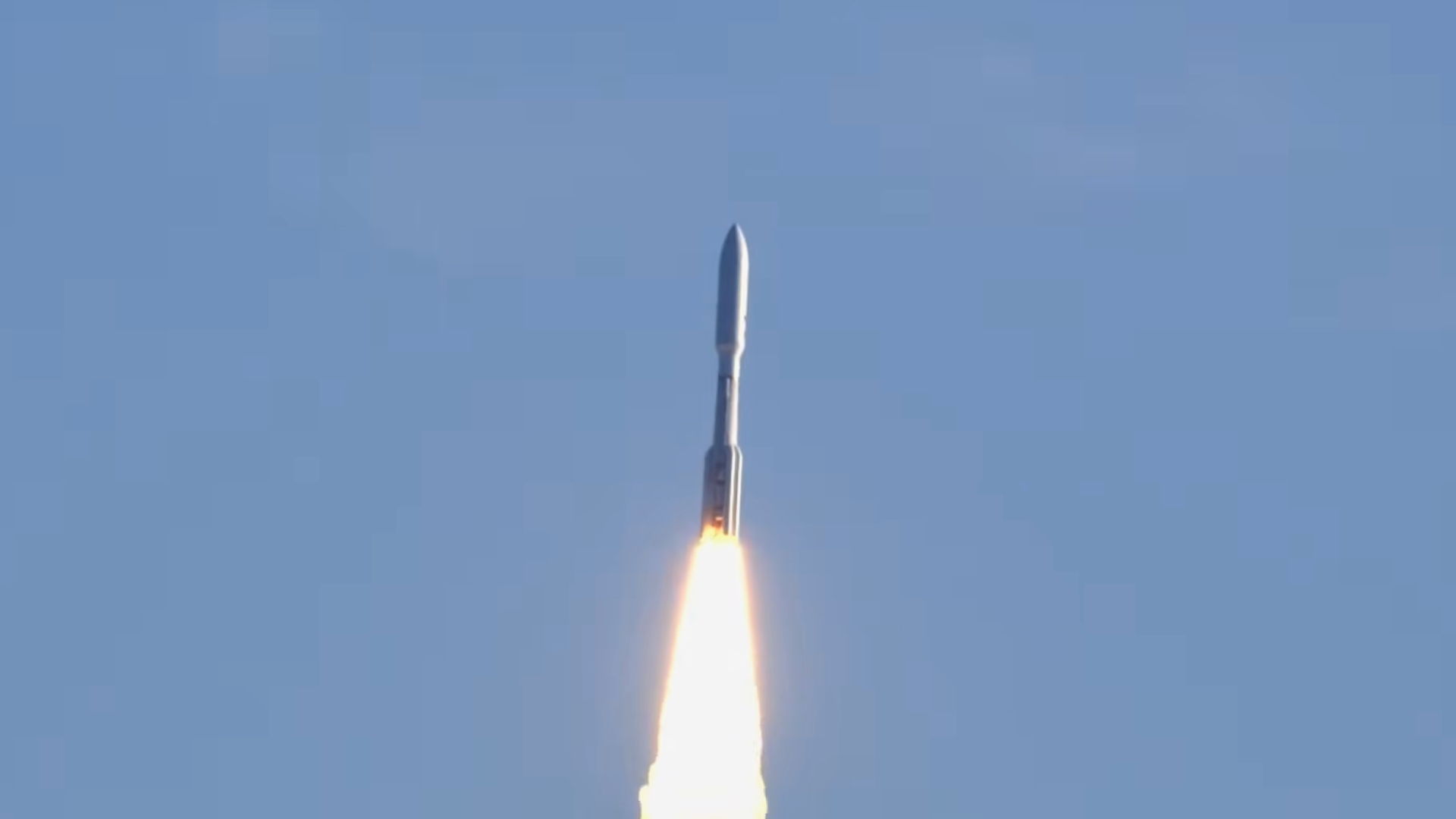 view of rocket flying through a blue sky