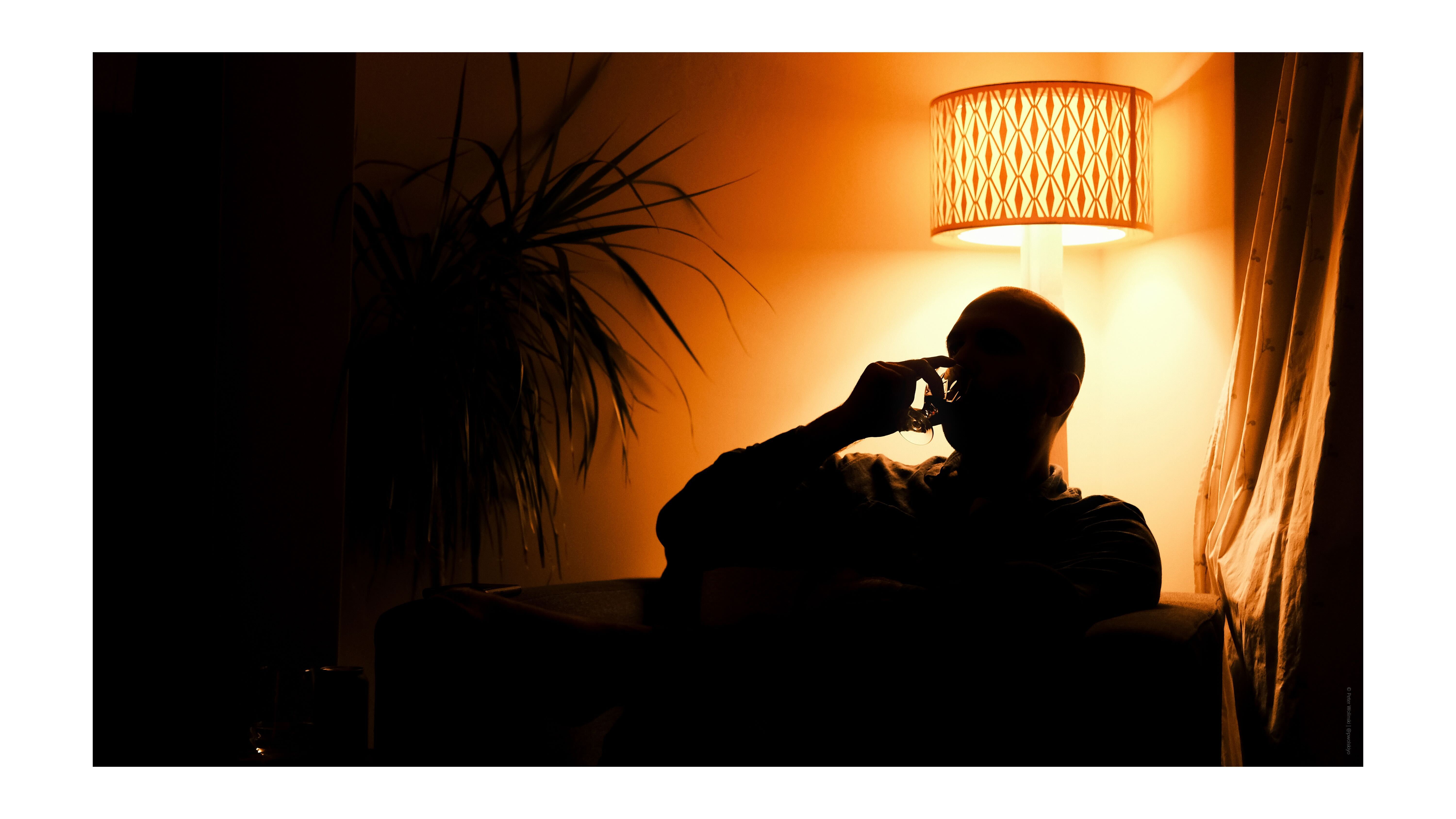 A photo of a man silhouetted against an orange light source