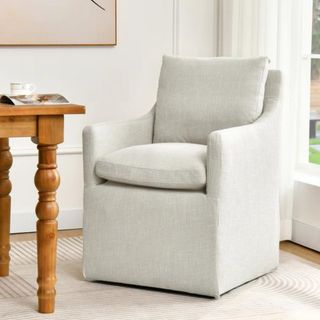 A light gray upholstered dining chair with arms from Wayfair