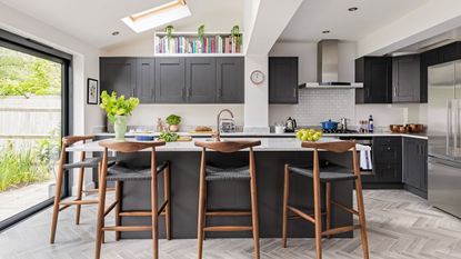 kitchen area with black cabinets and bricked wall