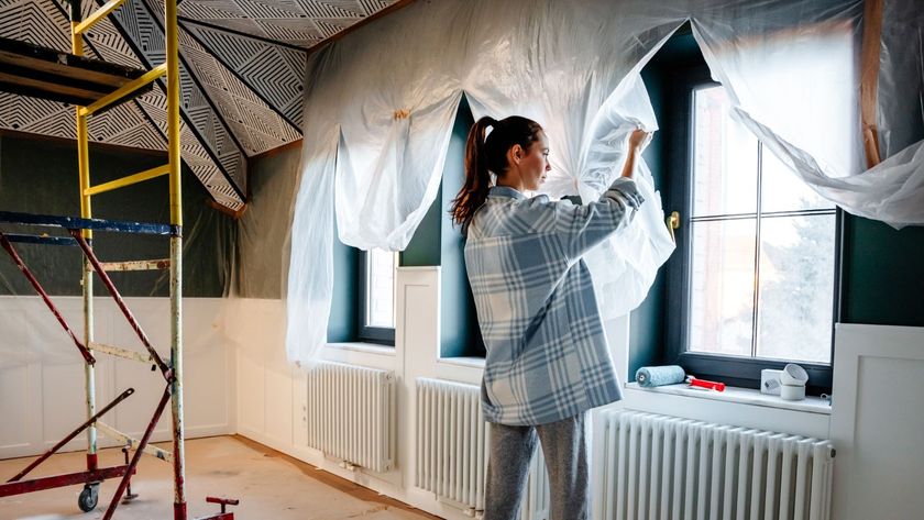 A woman is engaged in home improvement, removes protective polyethylene after repair