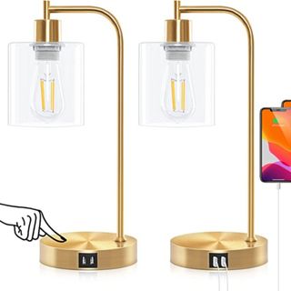 A pair of gold base lamps with glass shades and USB ports