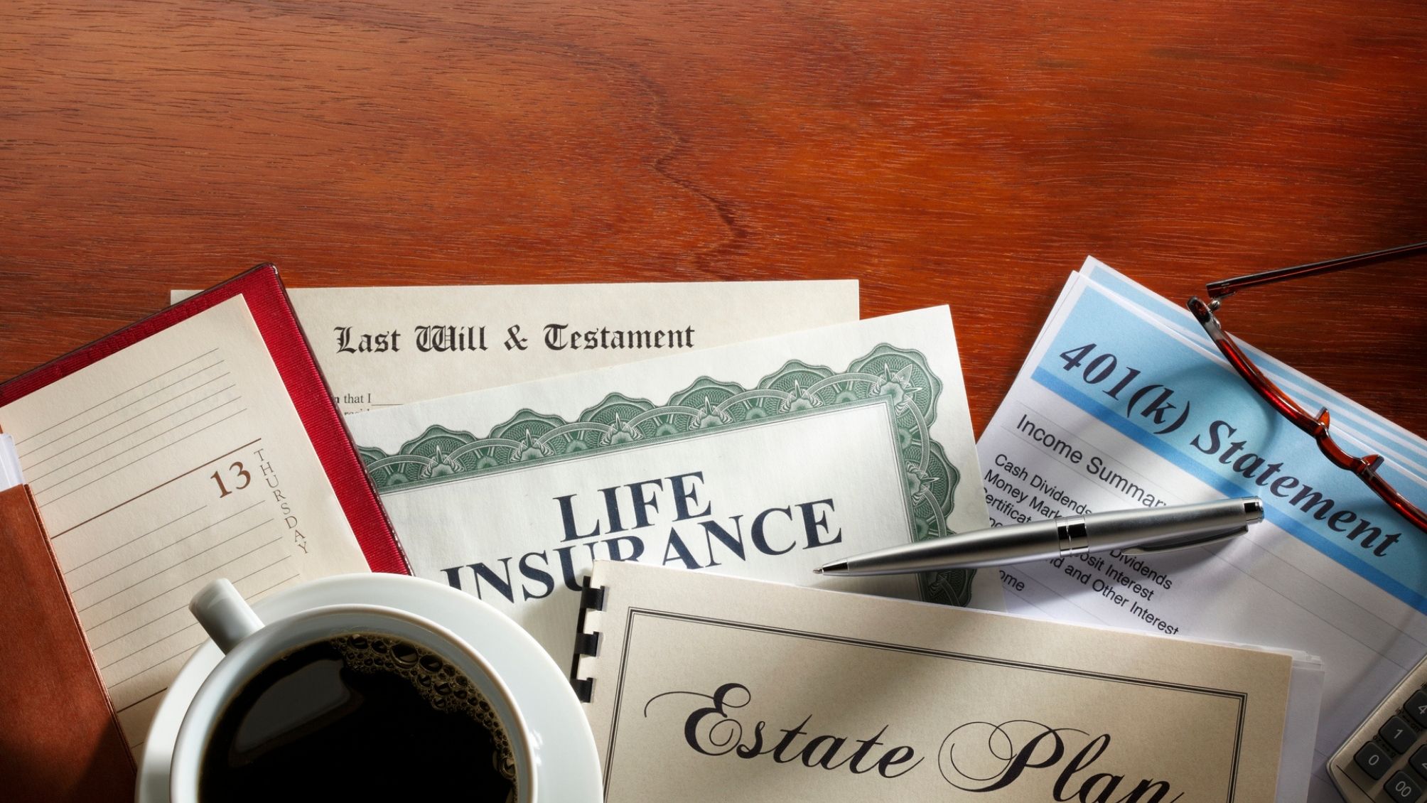 Estate planning documents sitting on a desk and a cup of coffee on the left side. 